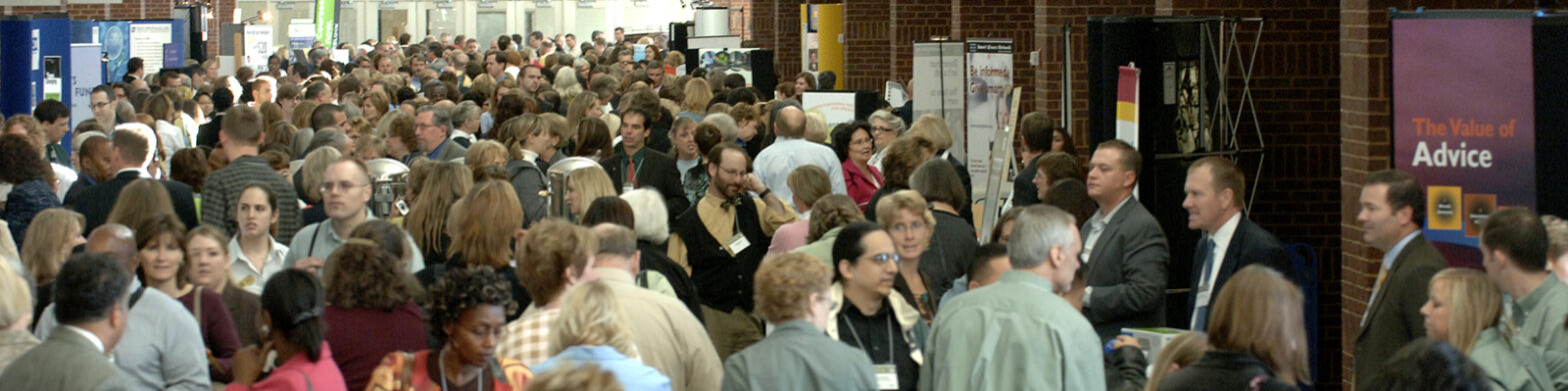 A lively conference scene with vendors at tables