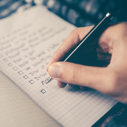 Writing a checklist on a pad of paper