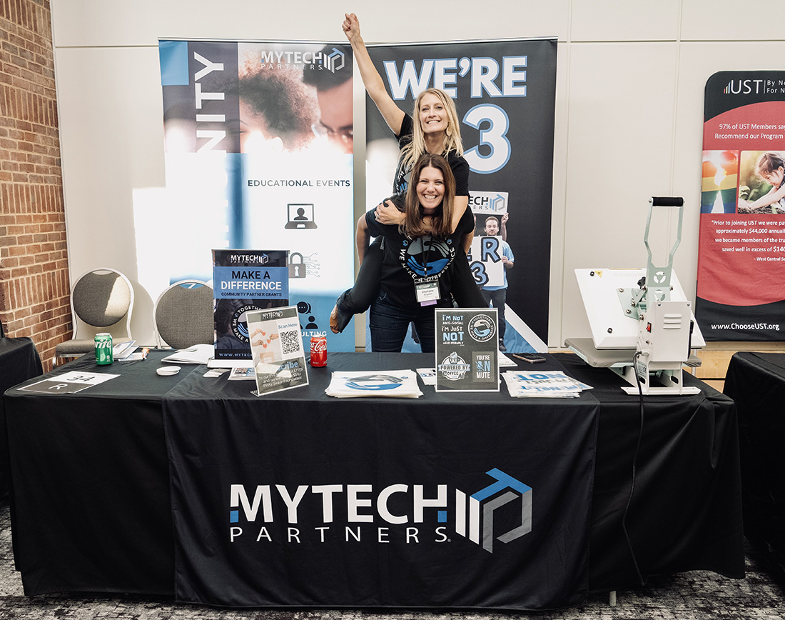 MyTech Partners team members celebrating in their exhibit booth at the 2024 MCN & MCF Joint Annual Conference in St. Paul.