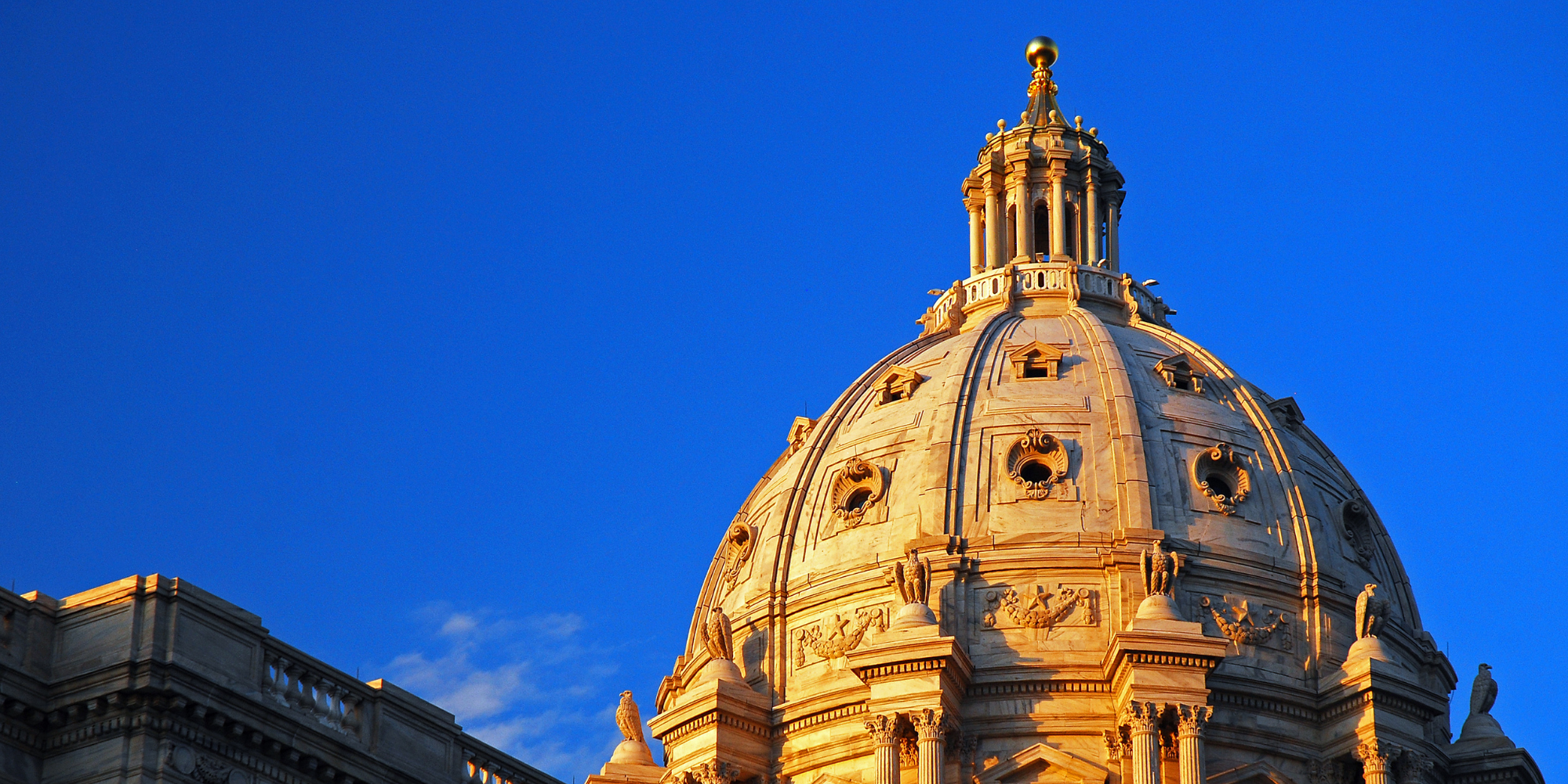 Color photograph of Minnesota State Capitol building dome against a blue sky
